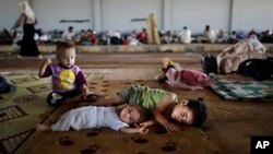 FILE - Syrian refugee children rest at a camp near the Turkish border. 