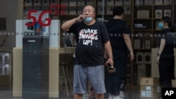 A Chinese man looks out near a Huawei store promoting 5G services in Beijing on July 22, 2020. 