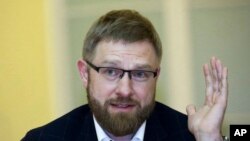 In this Thursday, April 19, 2018, photo, 'USA Really' editor Alexander Malkevich gestures while speaking at the plenary meeting of the forum "Society, Culture and Media" in St. Petersburg, Russia. As Americans prepare for another election, Russian troublemakers appear to laboring afresh to divide U.S. voters and discredit democracy, and perhaps even sway the outcome. 