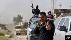 Pasukan keamanan Irak berpose saat merayakan pengambilalihan kota Fallujah di Irak dari kelompok Negara Islam (ISIS) (17/6).