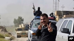 伊拉克特种部队与伊斯兰国武装激战后占领费卢杰市中心，庆祝胜利的伊拉克战士打成胜利的手势。 （2016年6月17日）