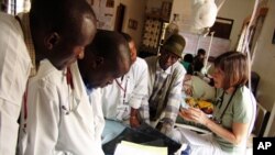 Sara Stulac (right), consults with colleagues at the Rwinkwavu Hospital in Eastern Rwanda. Stulac, director of pediatrics for Partners In Health, has designed a program which brings Rwandan physicians together with Boston-based pediatric oncologists.