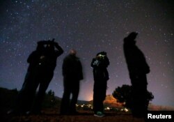 Orang-orang menggunakan kacamata night vision untuk melihat langit malam selama tur Unidentified Flying Object (UFO) di gurun di luar Sedona, Arizona 14 Februari 2013. (Foto: Reuters)