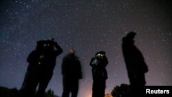 Beberapa orang tampak menggunakan kacamata untuk malam hari ketika ambil bagian dalam tur UFO di Sedona, Arizona, pada 14 Februari 2013. (Foto: Reuters/Mike Blake)