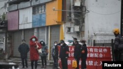  중국 베이징 외곽에 위치한 이민자 공동 거주 건물 앞에 시 당국자들이 보초를 서고 있다. (자료사진)