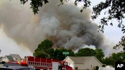 ເຈົ້າໜ້າທີ່ເຮັດວຽກເພື່ອຄວບຄຸມໄຟປ່າໃນເຂດປ່າ ຄາໂຣໄລນາ , ທາງທິດຕາເວັນຕົກຂອງເມືອງຣີສອດແຄມຝັ່ງທະເລຂອງ ມີເທີລ ບິສ ລັດຄາໂຣໄລນາ ໃຕ້ ວັນທີ 2 ມີນາ 2025 WMBF-TV ຜ່ານ AP 