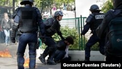 La police appréhende un manifestant lors des affrontements lors de la traditionnelle marche du travail du 1er mai à Paris, en France.