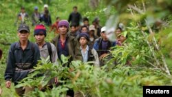 FILE - Montagnard hill tribesmen walk towards the main road after emerging from dense forest 70 km (43 miles) northeast of Ban Lung, located in Cambodia's northeastern province of Ratanakiri July 22, 2004. 
