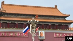 TOPSHOT - Russia's national flag flies beside the Chinese flag in front of Tiananmen Gate next to Tiananmen Square, during the state visit of Russia’s president Vladimir Putin in Beijing on May 16, 2024.