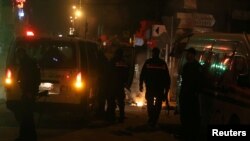 Des véhicules de police devant des pneus brûlés par des manifestantsà Tunis le 9 janvier 2018.