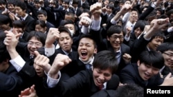 Japanese college students shout and raise their fists during a pep rally held to boost their morale ahead of their job hunt, at an outdoor theatre in Tokyo February 25, 2016. 