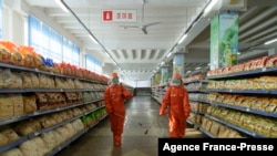 Employees spray disinfectant as part of preventative measures against the Covid-19 coronavirus at the Yokjon Department Store in Pyongyang on Oct. 20, 2021.