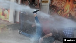 Turkish police use a water cannon to disperse demonstrators during a protest against the replacement of Kurdish mayors with state officials in three cities, in Diyarbakir, Aug. 19, 2019.