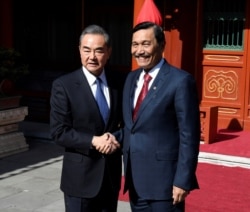 FILE - China's Foreign Minister Wang Yi shakes hands with Indonesia's Coordinating Minister for Maritime Affairs Luhut Pandjaitan before a meeting at the Diaoyutai State Guesthouse in Beijing, China, Oct. 24, 2018.