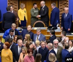 Presiden Ukraina Volodymyr Zelenskyy berjabat tangan dengan Presiden Estonia Alar Karis di samping PM Estonia Kaja Kallas (baju kuning) setelah memberikan pidato di depan parlemen Estonia (Riigikogu), di ibu kota Tallinn Kamis, 11 Januari 2024.