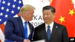 Presiden AS Donald Trump (kiri) berjabat tangan dengan Presiden China Xi Jinping di sela-sela pertemuan KTT G20 di Osaka, Jepang, 29 Juni 2019. (Foto: AP)