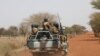 FILE - Burkina Faso soldiers patrol on a road in the Sahel area of Burkina Faso, March 3, 2019.