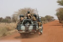 FILE - Burkina Faso soldiers patrol on a road in the Sahel area of Burkina Faso, March 3, 2019.
