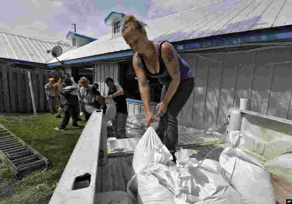 Krystal Day, of Homosassa, Fla., leads a sandbag assembly line at the Old Port Cove restaurant, Oct. 9, 2018, in Ozello, Fla.