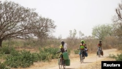 Les femmes transportent sur des bicyclettes des bidons d'eau vers le village de Bagare, province Passore, dans le nord du Burkina Faso, 30 mars 2016 