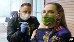 A volunteer vaccinator prepares to administer a dose of the Pfizer coronavirus vaccine at a vaccine centre in the Swaminarayan School in Neasden, north London, May 1, 2021.