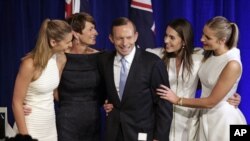 Tony Abbott (tengah) dikelilingi istri dan ketiga putrinya naik ke atas panggung merayakan kemenangan Abbott di Sydney, Sabtu (7/9).