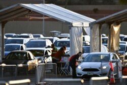 People receive their COVID-19 vaccines as the eligibility for vaccinations is opened to anyone over 16 across the state, at State Farm Stadium in Phoenix, Arizona, March 24, 2021.
