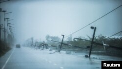 Tiang listrik yang ambruk terlihat di sepanjang jalan akibat hantaman badai tropis Pabuk saat mendekati provinsi selatan Nakhon Si Thammarat, Thailand, 4 Januari 2019.