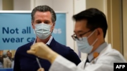 Governor Gavin Newsom watches as the Pfizer-BioNTech COVID-19 vaccine is prepared by Director of Inpatient Pharmacy David Cheng at Kaiser Permanente Los Angeles Medical Center in Los Angeles, California on December 14, 2020.