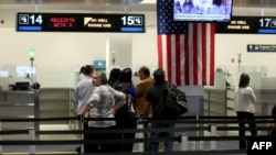 FILE - International travelers wait in line at a U.S. Customs and Border Protection checkpoint after arriving at Miami International Airport on March 4, 2015, in Miami, Florida.