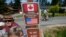 A family visits across the U.S.-Canada border at the Peace Arch Historical State Park as a cyclist rides past on the Canadian side, Aug. 9, 2021, in Blaine, Wash.