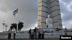 A Cuban flag flies at half-staff at Revolution Square as people gather following the announcement of the death of Cuban revolutionary leader Fidel Castro, in Havana, Cuba, Nov. 27, 2016. 