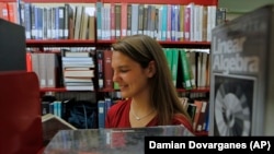 In this photo taken July 26, 2010, Brittany Wolfe, a University of California Los Angeles Applied Mathematics 2010 graduate, checks old text books at the UCLA Powell Library Building, in Los Angeles.