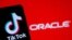 A smartphone with the Tik Tok logo is seen in front of a displayed Oracle logo in this illustration taken, Sept. 14, 2020. 