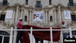 Workers do the final touches to one of the podiums near Havana's cathedral, that will be used during visit of Pope Francis, Cuba, Sept. 17, 2015. 