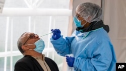 គ្រូ​ពេទ្យ​ម្នាក់​កំពុង​យក​សំណាក​សារធាតុ​រាវ​ពី​​បុរស​ម្នាក់​ដើម្បី​យក​ទៅ​ធ្វើ​តេស្ត​រក​វីរុស​កូរ៉ូណា នៅ​​រដ្ឋ Indianapolis ថ្ងៃទី​២៣ ខែមេសា ឆ្នាំ​២០២០។