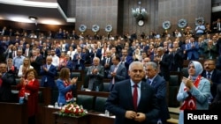 PM Turki, Binali Yildrim (depan) berbicara di depan anggota parlemen dari Partai AKP yang berkuasa selama peremuan dengan parlemen Turki. Ankara, Turki (19/7). (foto: REUTERS/Umit Bektas)
