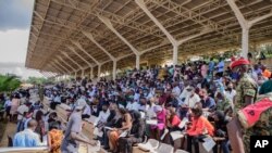 FILE - People wait in stands to get vaccinated against COVID, at the Kololo airstrip in Kampala, Uganda, May 31, 2021.
