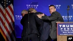 Agen Secret Service mengungsikan capres Donald Trump dari panggung saat berkampanye di Reno, Nevada, 5 November 2016.