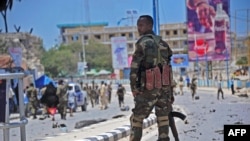 Un membre des services de sécurité somaliens patrouille sur les lieux d'un attentat suicide à la voiture piégée à Mogadiscio, le 30 août 2016.