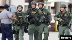 Law enforcement personnel walk near the scene where police officers were shot in Baton Rouge, Louisiana, U.S. July 17, 2016. (REUTERS/Jonathan Bachman)