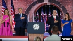 Presiden AS Donald Trump, Ibu Negara Melania Trump, Wapres AS Mike Pence dan istrinya, Karen Pence memberikan penghormatan saat Lagu Kebangsaan AS dikumandangkan oleh Trance Atkins dalam Konvensi Partai Republik di Fort McHenry, Baltimore, Maryland, 26 Agustus 2020. 