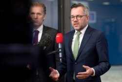 FILE - German Minister of State for European Affairs Michael Roth, right, speaks with the media as he arrives at the Europa building in Brussels, Dec. 11, 2018.
