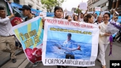 FILE - Vietnamese protesters hold a banner reading 'We love the sea, fish and shrimp. Formosa get out' during a rally denouncing recent mass fish deaths in Vietnam's central province, in Hanoi, Vietnam, 01 May 2016. 