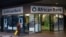 FILE - A cleaner walks past a branch of African Bank in Cape Town.