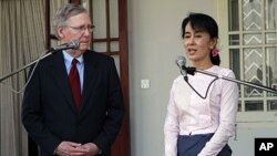 U.S. Senator Mitch McConnell, left, listens to Burmese pro-democracy leader Aung San Suu Kyi talk to journalists during a press conference after their meeting at her home in Yangon. The Obama administration has support from key Republicans to restore full
