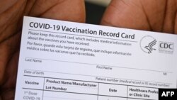 ARHIVA - Zdravstveni radnik u Los Anđelesu pokazuje zvaničnu potvrdu o vakcinaciji