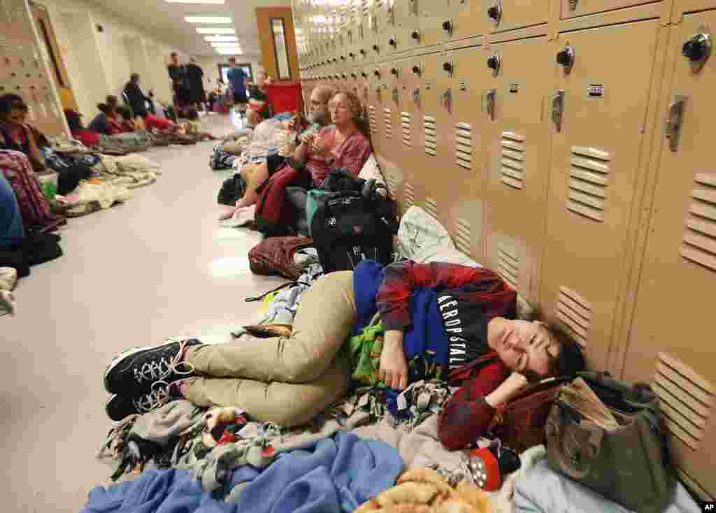 Emily Hindle lies on the floor at an evacuation shelter set up at Rutherford High School, in advance of Hurricane Michael, which made landfall, in Panama City Beach, Fla., Oct. 10, 2018.