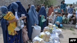 Afghan women receive food donations as part of the World Food Program (WFP) for displaced people, during the Islamic holy month of Ramadan in Jalalabad, Apr. 20, 2021.