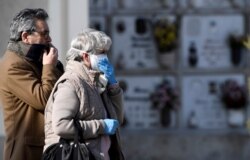 Relatives attend the funeral of a woman who died from the coronavirus disease, as Italy struggles to contain the spread of COVID-19 in Seriate, March 28, 2020.